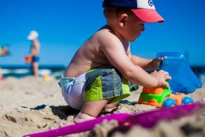 A little boy playing in the sand on a sunny beach