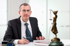 A lawyer looking straight into the photo holding a pen. Branding a legal firm is serious business 