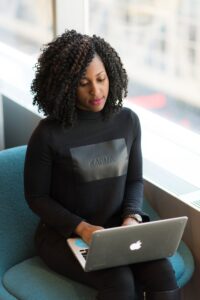 Woman sitting looking at her screen. Planning her online business 