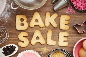 Bake Sale is written in big letters made out of cake. Host a fundraiser with a bake sale. 