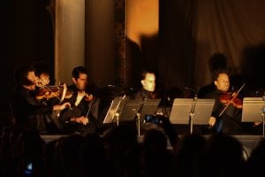 An orchestra performing in a dark room 