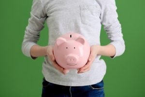 A pair of hands holding a pink piggy bank to try to symbolize branding on a budget