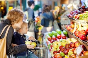 Little boy looking at all the colorful fruits and vegetables at a market with his mother. Starting and selling your own produce for the farming industry is one of the best jobs you can find. 