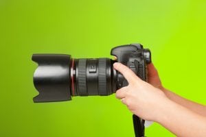 A pair of hands holding a camera. To have a wedding photography business is a dream for a lot of people. 