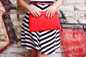 Designer clothes. A black and white striped dress with details like a red handbag and a red belt. Fashion Accessory business is unlimited in what you can sell. 