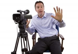 A man sitting on the film makers chair. To start your own film directing business is not easy but not impossible. 