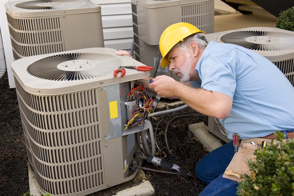 A man fixing an airconditioner. To o market a HVAC you need to be clever and put in a lot of effort