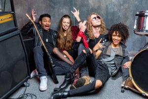 A band sitting on the floor after a gig. 