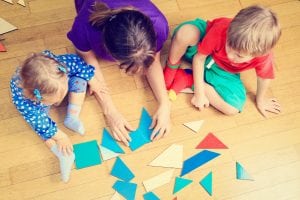 Three children playing on the floor. 