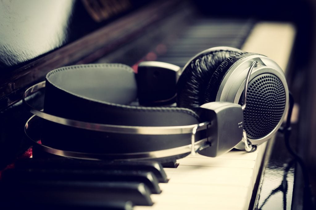 A pair of headphones on top of a piano in a music studio