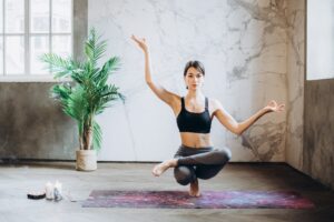 Woman posing a complicated yoga pose. Balancing. 