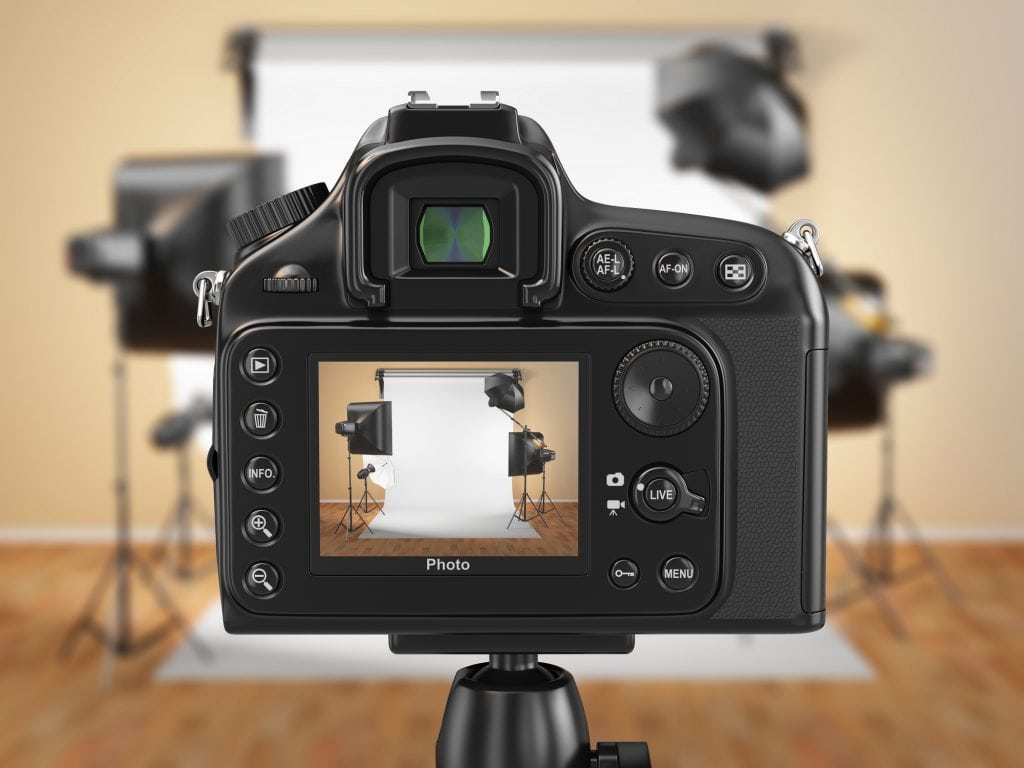 A camera showing a studio setup in it's lens. Starting your own photography business requires good equipment