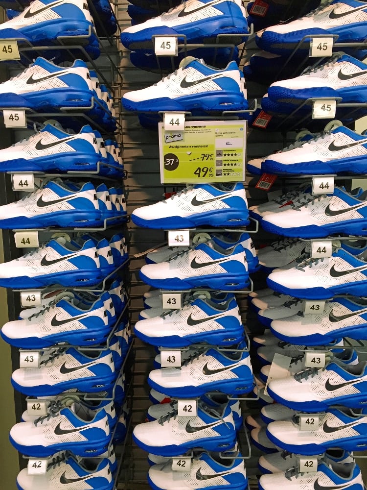 Lots of white and blue football shoes. When marketing your sport shop you need the shop to look super well organized