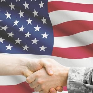 Hand shake in from of the US flag. Marketing your patriotic business required symbols like colors in red, white and blue. 