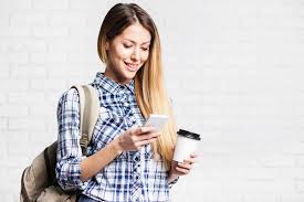 Young woman looking at her mobile phone screen, marketing to college students is important however make it sweet and simple as their attention span is very short.