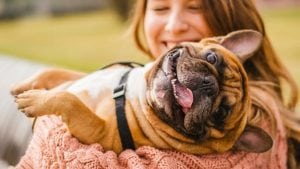 Logo designing for Pet owners requires an understanding of the love the have for their animals. Bulldog in a woman's arms smiling