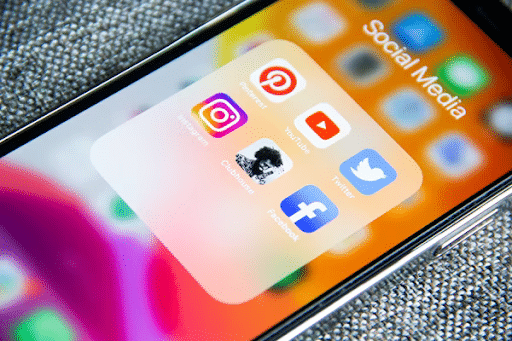 To o have a strong social media presence in all the channels you need to make a competitive analysis. Mobile phone showing icons over social media.