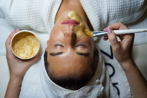 Wellness logo design showing a woman putting on a face mask.