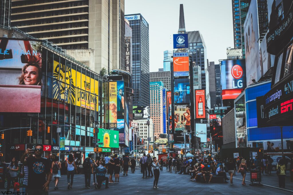 Photo of New York with lots of New York logo designs on the billboards.