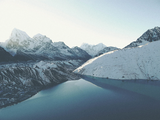 snow-covered mountainscape with lake at the base