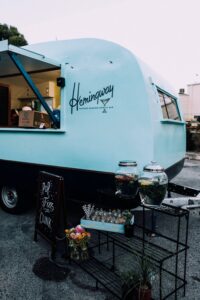 Caravan with a retail logo on that says Hemingway with a cocktail glass. 