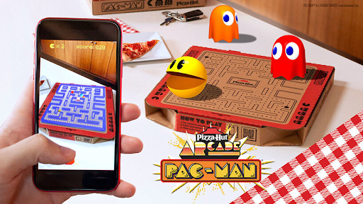 Image by Pizza hut. A hand photographing PAC-MAN retro marketing Pizza Hut