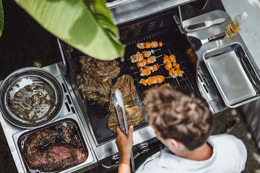 A guy cooking up meat on a BBQ promoting and marketing a BBQ Business