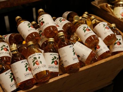 Assortment of Bottled Apple Juice in Wooden Crate. Craft Beverage Logo Design on a Swedish apple juice bottle