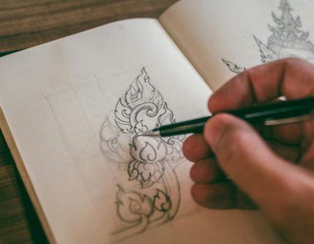 Person making a hand-drawn logo on a Booklet
