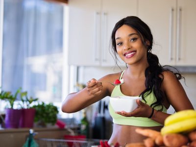 This is a girl eating healthy stuff in a kitchen. A wellness website needs to stand out from the crowd and be extremely professional. Use a website designer.