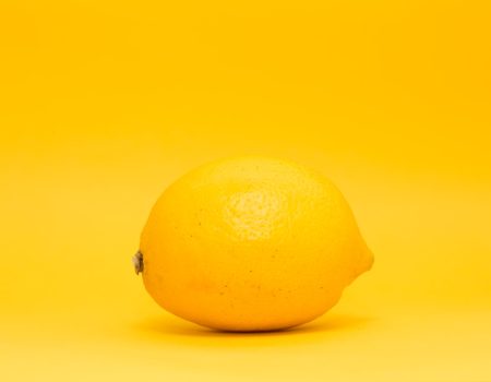 Bright yellow lemon on a yellow background