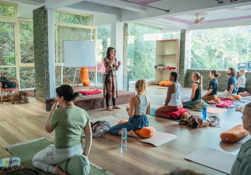 A woman holding her yoga class, explains to the students. Great marketing your yoga studio on social media