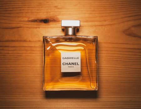 Clear Glass Perfume Bottle for a luxury brand called Chanel on Brown Surface