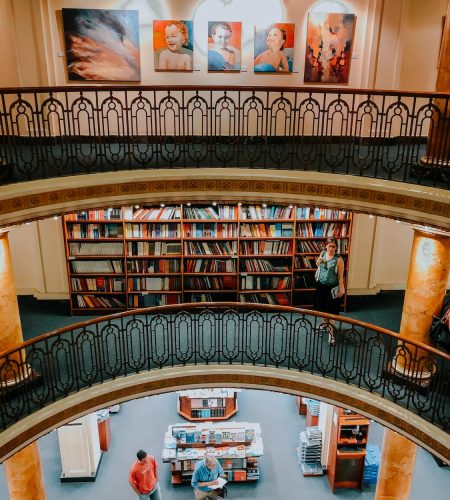 A library full of traditional paintings on the walls.Traditional vs digital art is always a questions.