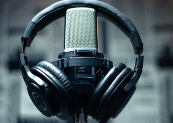 Headphones on a professional microphone. Quality audio for your podcast is crucial to have and retain listeners.