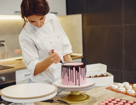 Woman decorating a cake, working in the food service industry