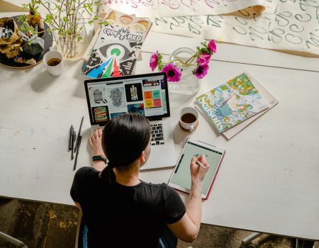 Photo of Woman Writing on Tablet Computer While Using Laptop. Practising to get the perfect canvas size for digital art