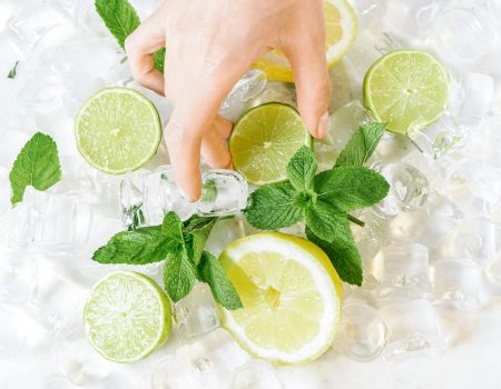 Shot of a Hand Touching Lime in Ice Cubes. Great summer color trends. Shot of a Hand Touching Lime in Ice Cubes. Great summer color trends.
