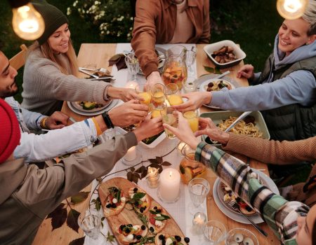 Friends around the table Doing a Friendsgiving Toasts