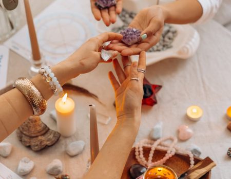 Powerful stones and candles on a tray. Hands touching stones. A healing business