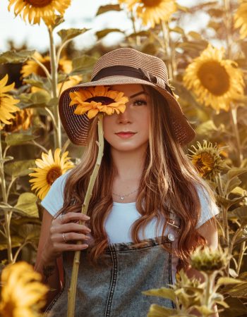 Girl in a field of sunflowers. Summer logo ideas can be something as easy as using yellow in your logo