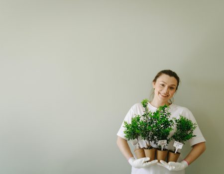 Woman In White Shirt Holding Potted Plants Woman In White Shirt Holding Potted Plant with eco-inspired logo design labels