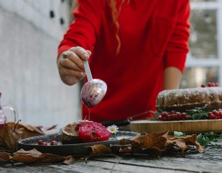 Woman decorating dessert with sweet syrup. Christmas bakery logo design in the making.